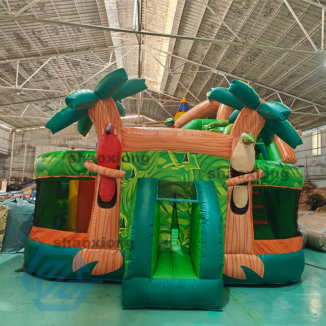 Casa de rebote inflable con tema de selva tropical y tobog&aacute;n